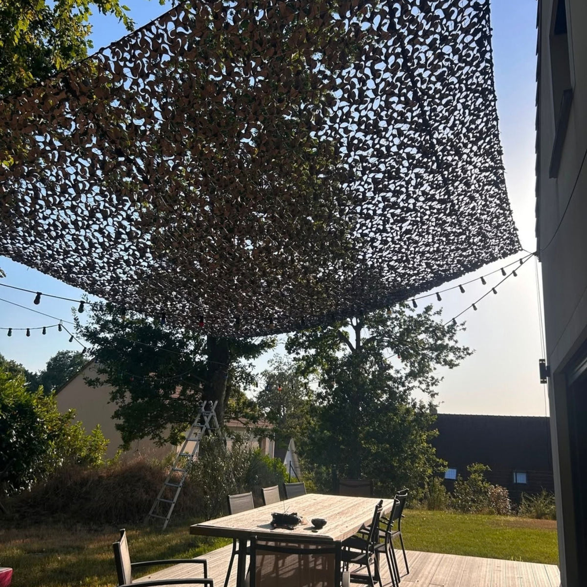 Filet de camouflage gris faisant de l'ombre sur une table de jardin