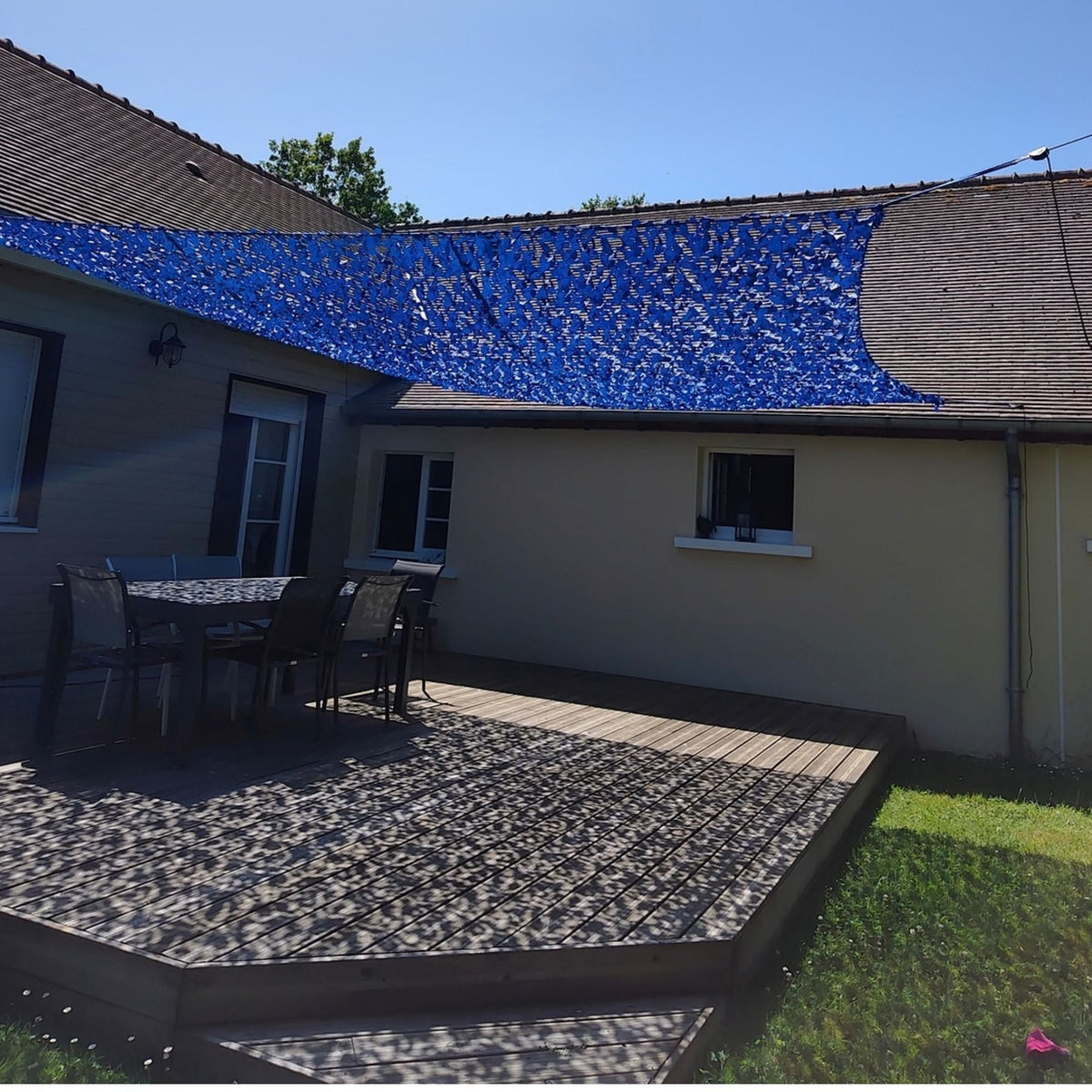 Filet de camouflage renforcé bleu en voile d'ombrage sur une terrasse en bois