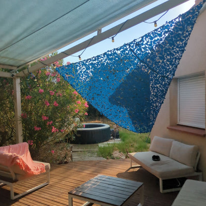 Filet de camouflage triangulaire bleu au-dessus d'une terrasse avec canapé