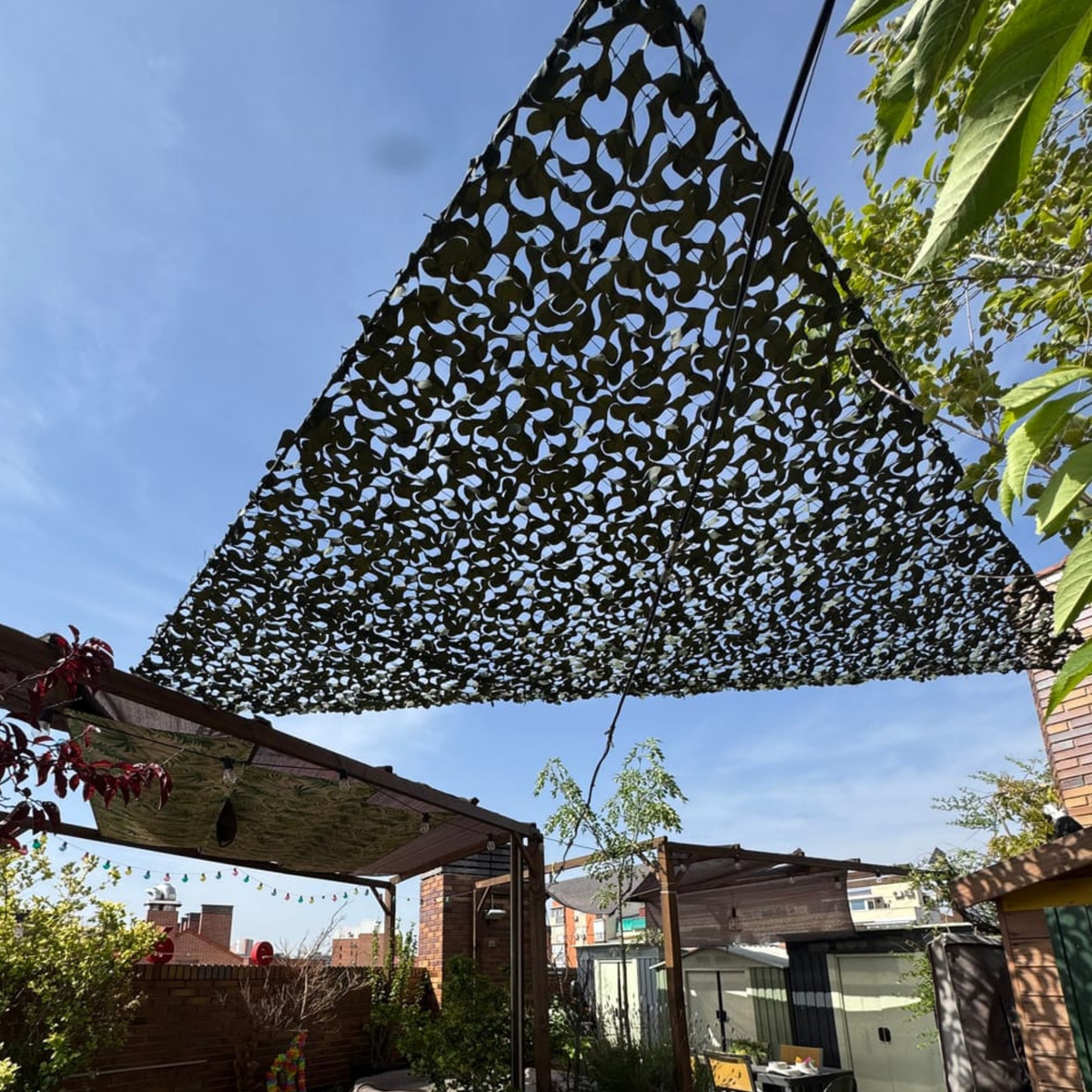 Filet de camouflage triangulaire sombre sur une pergola de jardin